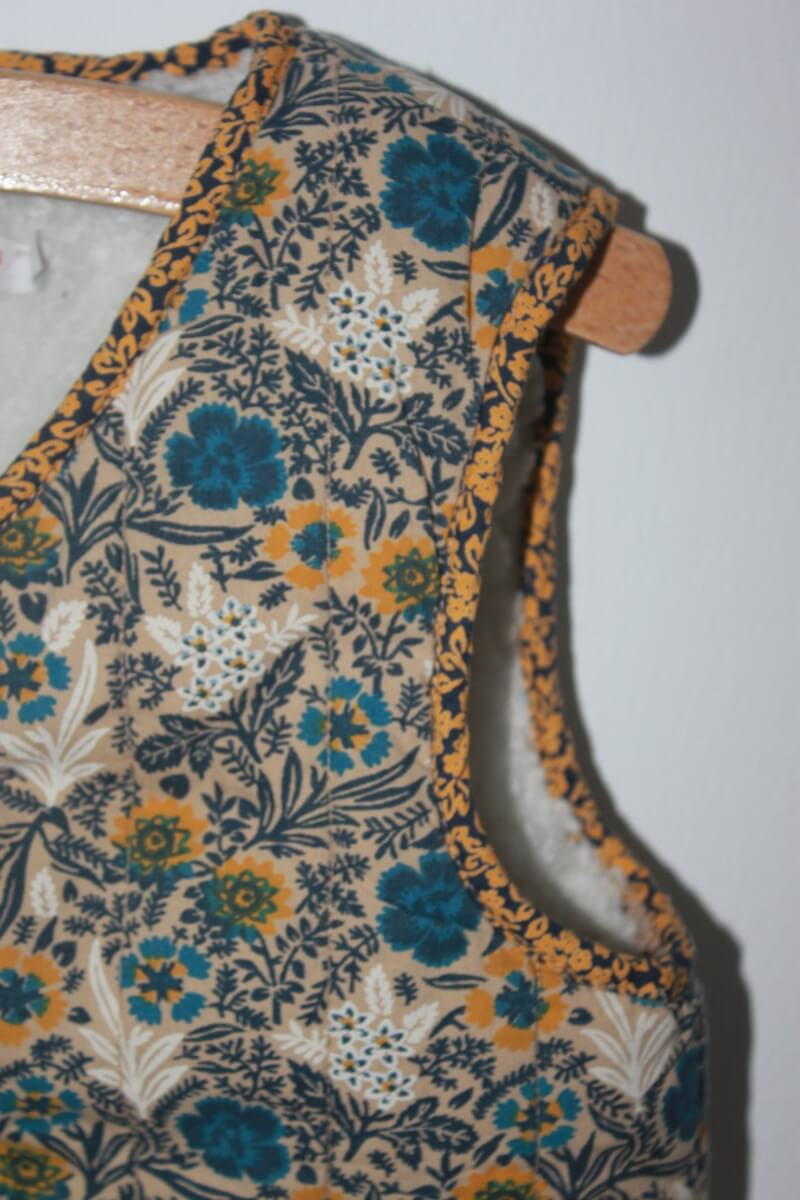 tweedehands gebloemd mouwloos vest in multicolour van monoprix in maat 104 voor een meisje. Gevoerd met imitatie schapenvacht 