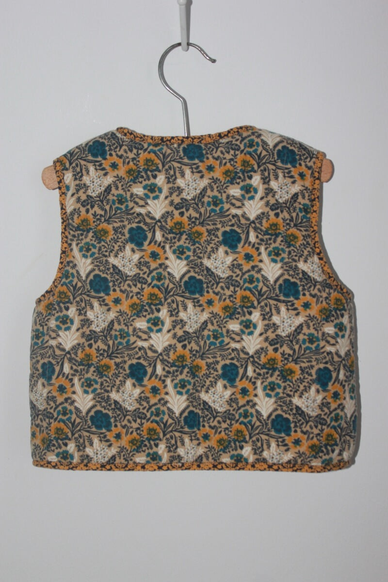 tweedehands gebloemd mouwloos vest in multicolour van monoprix in maat 104 voor een meisje. Gevoerd met imitatie schapenvacht 